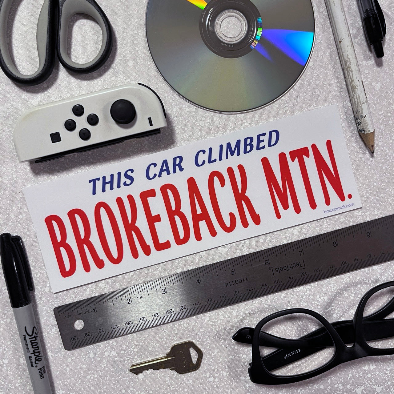 Red white and blue sticker says This Car Climbed Brokeback Mtn.